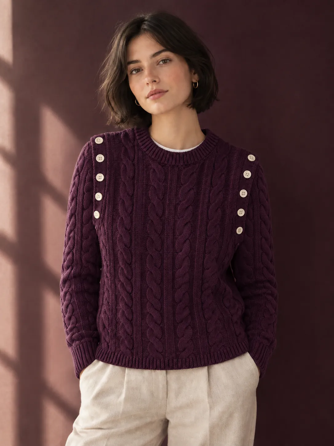 The same woman with plum cable sleeves buttoned onto the vest, now a jumper